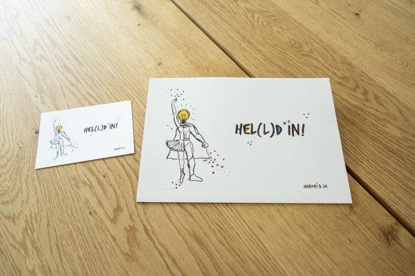weiße Postkarte mit bunter Schrift "Hel(l)d*in"